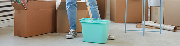 a person using a mop and bucket to wipe down a floor